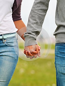 Mid section image of a couple holding hands