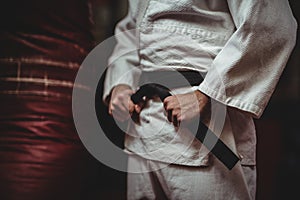 Mid section of karate player tying his belt