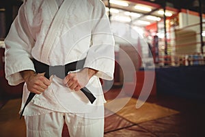 Mid section of karate player tying his belt