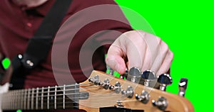 Mid section male musician adjusting tuners