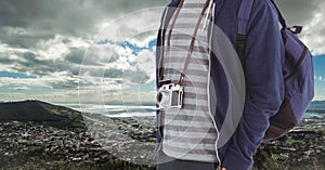 Mid section of man with digital camera and backpack