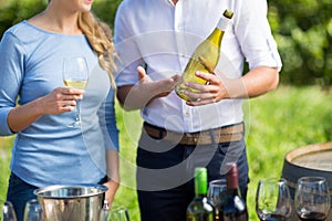 Mid section of man showing wine bottle