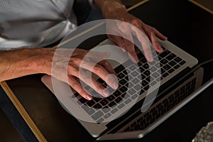 Mid section of man using laptop at table