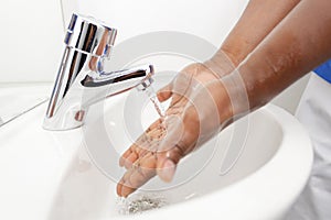 mid section man washing hands in kitchen