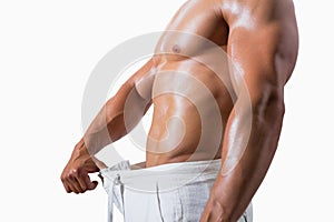 Mid section of a muscular man in an over sized pants