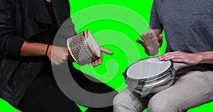 Mid section of musicians playing cabasa and drum