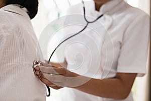 Mid section of nurse examining patient