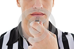 Mid section of referee blowing whistle
