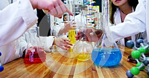 Mid section of schoolkids experimenting chemical in laboratory 4k