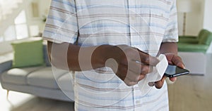 Mid section of senior man wiping his smartphone with a tissue