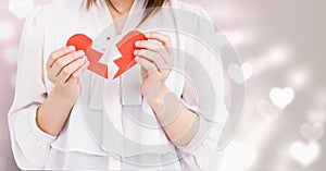 Mid-section of woman holding a broken heart