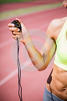 Mid-section of woman holding stop watch