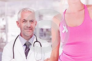 Composite image of mid section of woman wearing breast cancer awareness ribbon