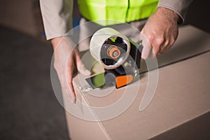 Mid section of worker preparing goods for dispatch