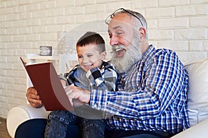 Mid side shot of elated granfather and his son while reading a s