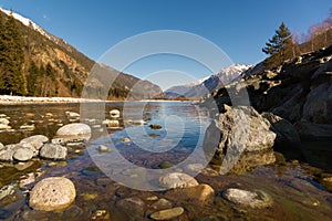 Midday Autumn landscape calm river in the Caucasus Mountains with rocks in the near term