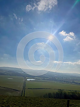 Midday sun over the fields and hills