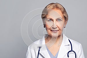 Middle adge doctor woman wearing medical uniform over grey background smiling cheerful, mature face close up photo