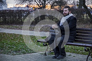 Middle adult calm bearded man sitting on bench lonely melancholy mood in autumn park dray ordinary day