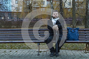 Middle adult calm bearded man sitting on bench lonely melancholy mood in autumn park dray ordinary day