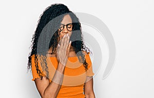 Middle age african american woman wearing casual clothes and glasses bored yawning tired covering mouth with hand