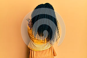 Middle age african american woman wearing wool winter sweater and leather jacket hugging oneself happy and positive from backwards