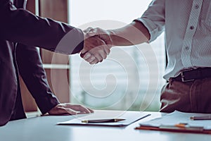 Middle age Asian partner lawyers attorneys shaking hands after discussing a contract agreement done photo