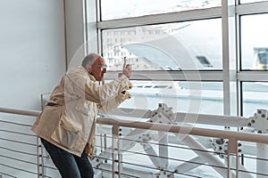 middle age bald man taking photo with smart phone in waiting room at port - Happy tourist traveling by cruise ship