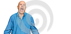 Middle age bald man wearing casual clothes angry and mad screaming frustrated and furious, shouting with anger