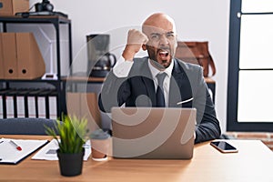 Middle age bald man working at the office annoyed and frustrated shouting with anger, yelling crazy with anger and hand raised