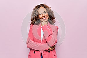 Middle age beautiful businesswoman wearing jacket standing over isolated pink background smiling looking confident at the camera