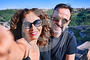 Middle age beautiful couple wearing casual clothes and sunglasses