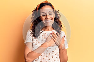 Middle age beautiful woman wearing casual t shirt smiling with hands on chest, eyes closed with grateful gesture on face