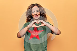 Middle age beautiful woman wearing t-shirt with red star revolutionary symbol of communism smiling in love doing heart symbol