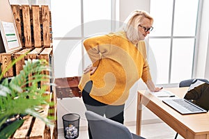 Middle age blonde woman business worker suffering for backache at office