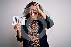 Middle age brunette business woman stressed holding banner with help word message with happy face smiling doing ok sign with hand