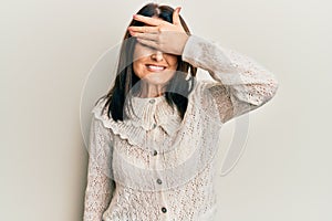 Middle age brunette woman wearing casual clothes smiling and laughing with hand on face covering eyes for surprise