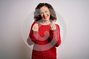 Middle age brunette woman wearing casual sweater standing over isolated white background doing money gesture with hands, asking