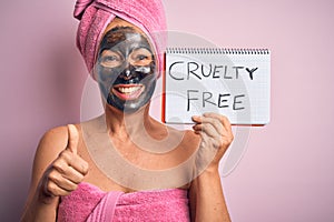 Middle age brunette woman wearing cruelty free beauty black face mask happy with big smile doing ok sign, thumb up with fingers,