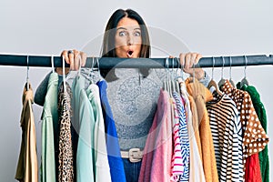 Middle age brunette woman working as professional personal shopper afraid and shocked with surprise and amazed expression, fear