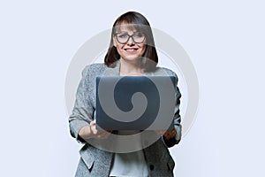 Middle age business woman with laptop looking at camera on white background