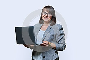 Middle age business woman with laptop looking at camera on white background