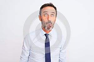 Middle age businessman wearing elegant tie standing over isolated white background making fish face with lips, crazy and comical