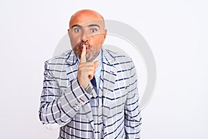 Middle age businessman wearing suit standing over isolated white background asking to be quiet with finger on lips