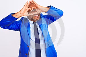 Middle age businessman wearing suit standing over isolated white background Doing heart shape with hand and fingers smiling