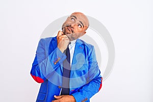 Middle age businessman wearing suit standing over isolated white background with hand on chin thinking about question, pensive