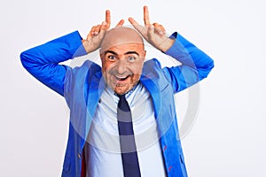 Middle age businessman wearing suit standing over isolated white background Posing funny and crazy with fingers on head as bunny