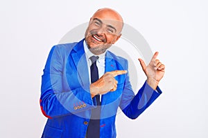 Middle age businessman wearing suit standing over isolated white background smiling and looking at the camera pointing with two