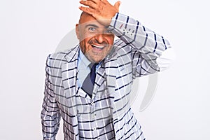 Middle age businessman wearing suit standing over isolated white background surprised with hand on head for mistake, remember