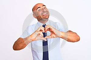 Middle age businessman wearing tie standing over isolated white background smiling in love doing heart symbol shape with hands
